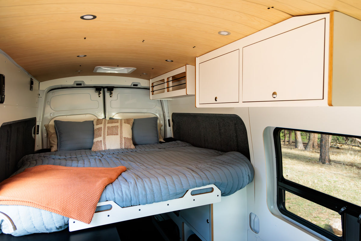 Queen bed with overhead cabinetry under the birch ceiling